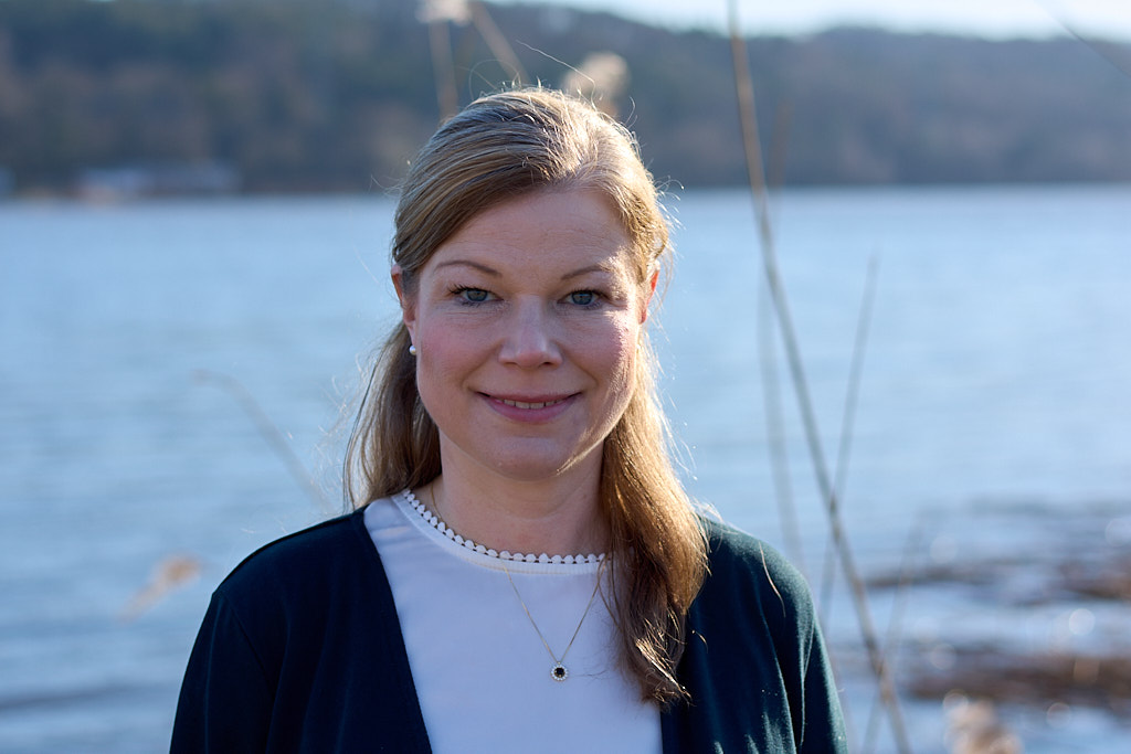 Portrait von Dr. med. Annegret Chao. Sie lächelt in die Kamera und steht vor einem verschwommenen Fluss-Hintergrund.